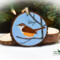A Carolina wren hand-painted on a wood slice Christmas ornament available for purchase at Cove Creek Photography.